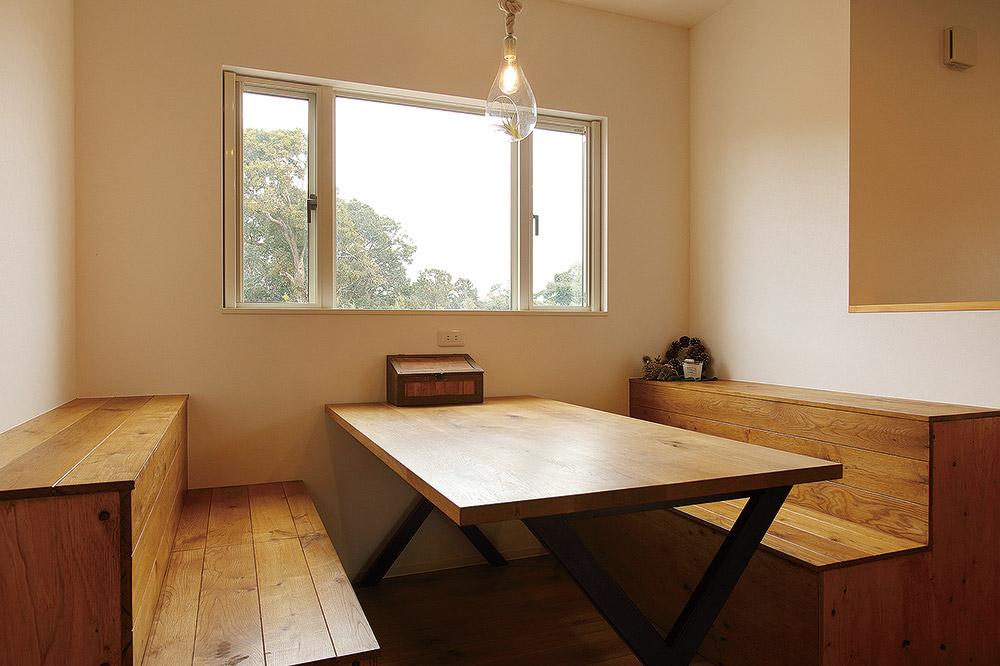 外の自然風景と家の質感に調和した造作ダイニングテーブル＆チェア。イスには収納機能も持たせている