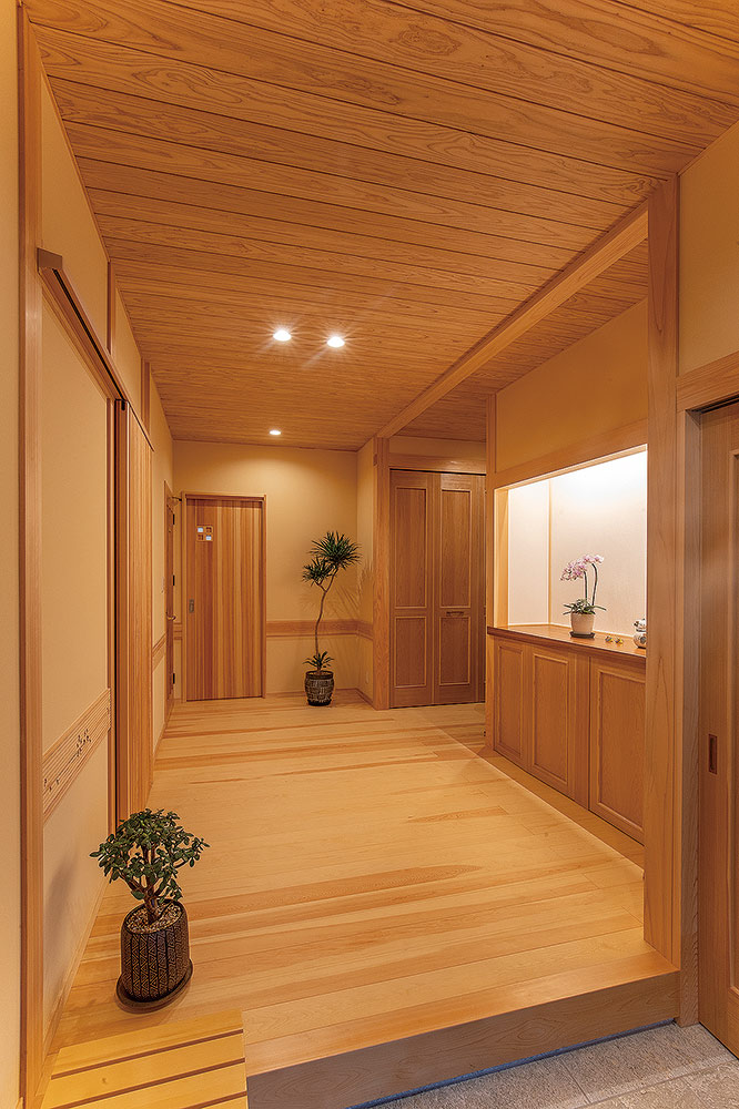 玄関扉を開けると広がる、木造りの空間。この先に広がる動線には、広々な収納スペースが