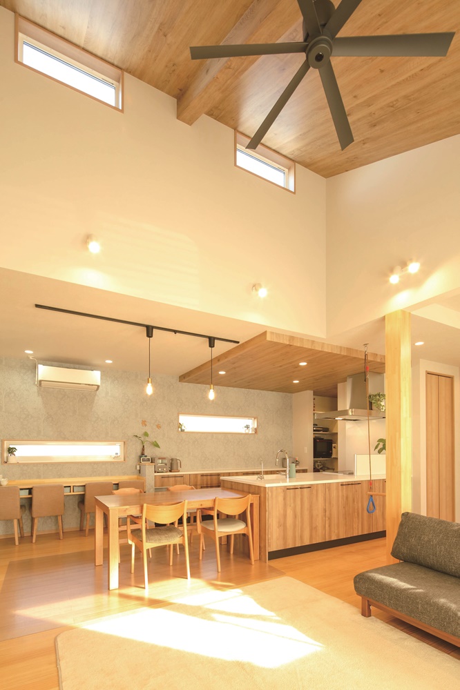 開放的な居住空間を実現する勾配天井。窓からのやわらかな光がリビングを照らす。デザイン性だけでなく冷暖房効率を高めるシーリングファンで省エネも